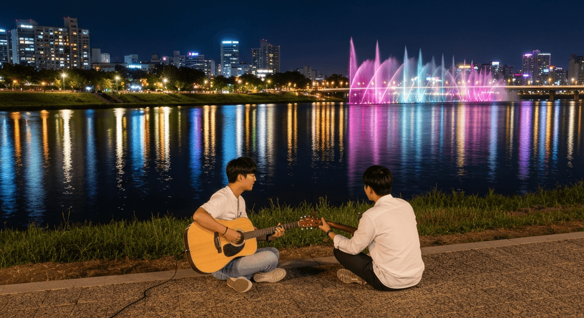Visitors sitting on the grass at Banpo Han River Park at night with fountain show in the background and city lights reflecting on the river