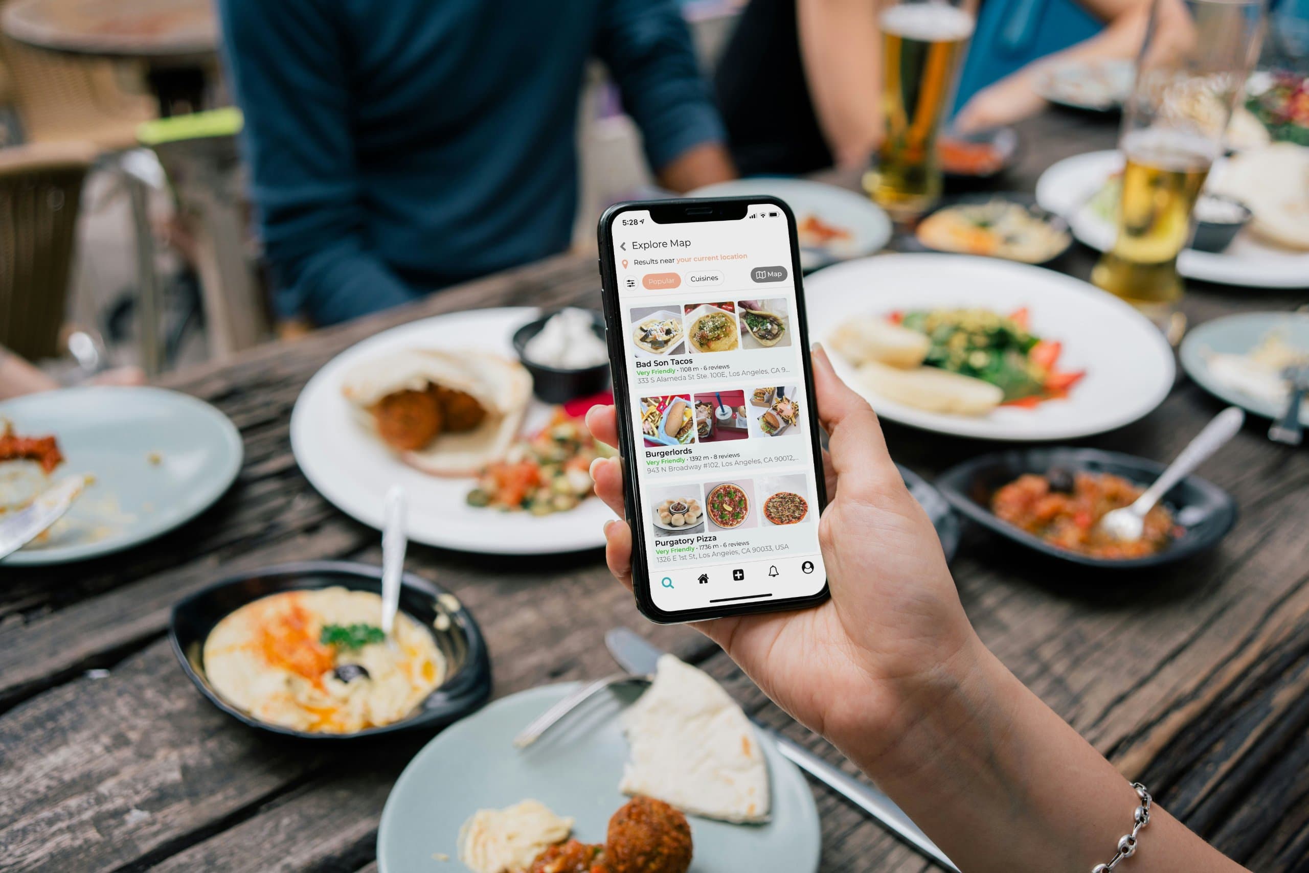 A person using a food delivery app on a smartphone while dining at a table